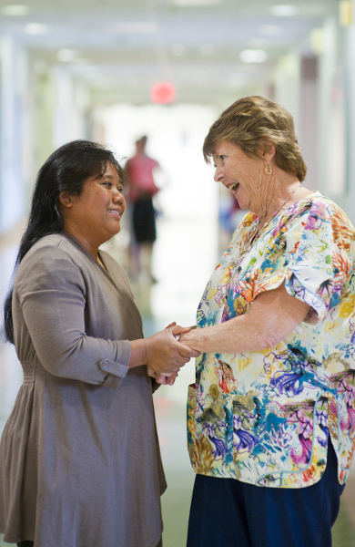 Two women embracing in medical center hallway