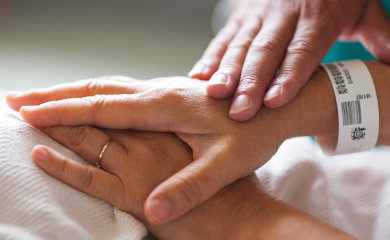 patient holding hands with a loved one