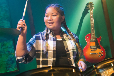 Cancer survivor Taylor playing the drums