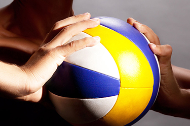 athlete holding a volleyball with both hands