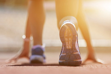 a runner crouches into a starting stance in anticipation for a race