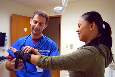 patient getting hand examined by doctor