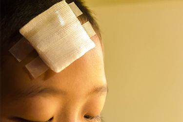 Boy with a bandage on his forehead