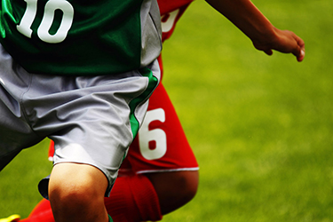 Two people playing soccer together