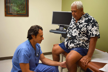 A man getting his knee examined by doctor