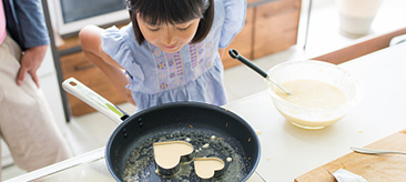 Child cooking heart shaped pancakes