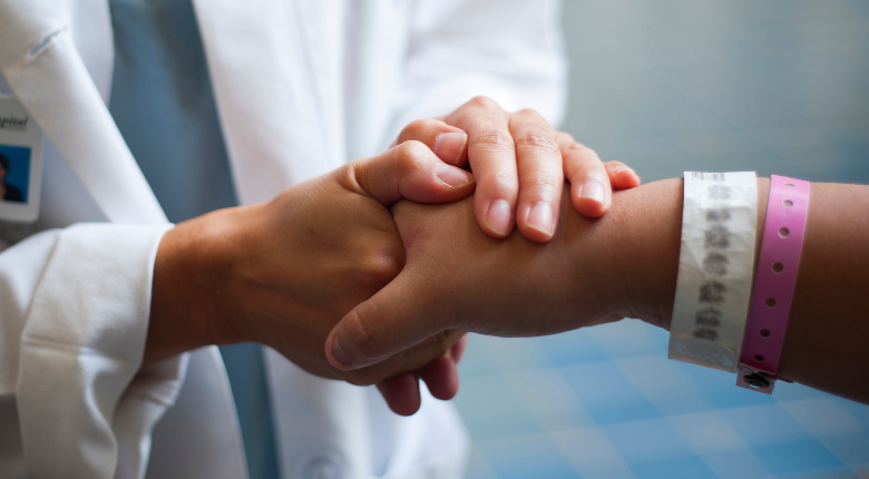 Doctor holding patient's hand