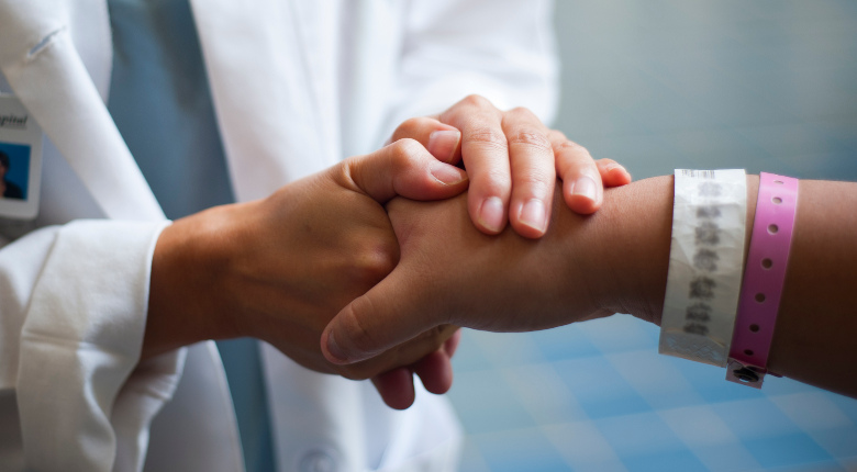 Doctor holding patient's hand