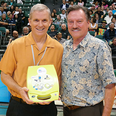 Two men holding a defibrillator