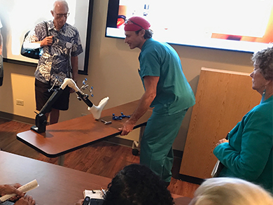 Physician demonstrates how a robotics-assisted handpiece is used for knee replacement procedures.