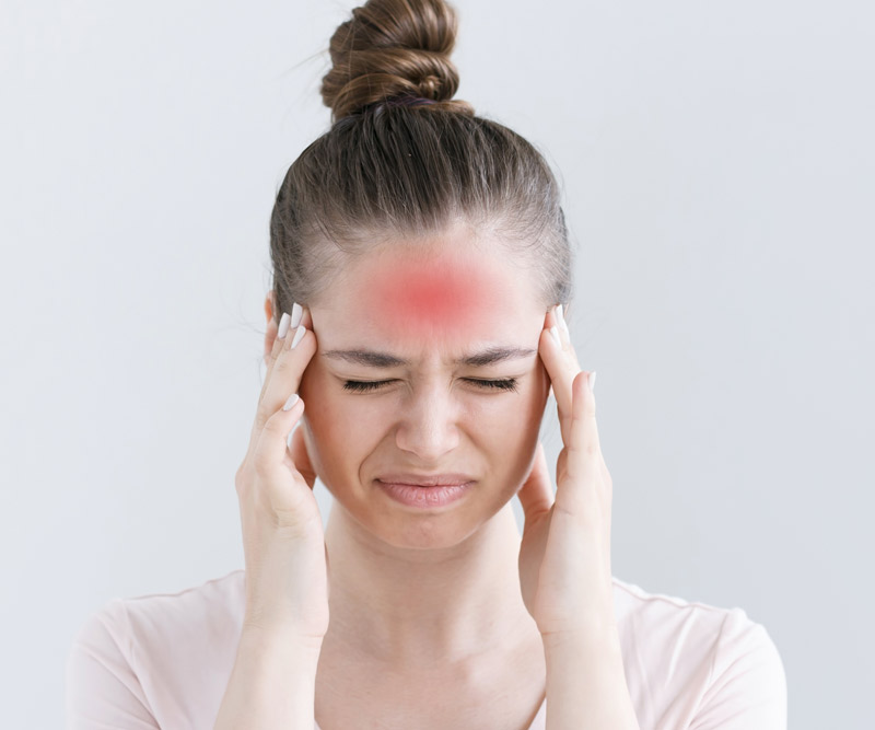 Woman with a headache holds her head in pain