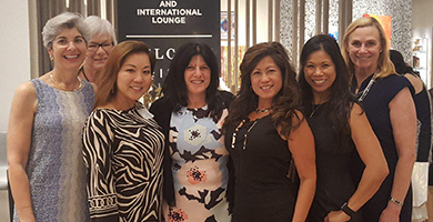 Seven women standing in a group smiling