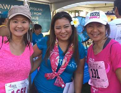 Three women in work out clothe smiling at the camera