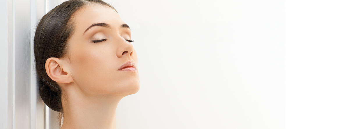 Face and Neck of a women with brown hair and closed eyes