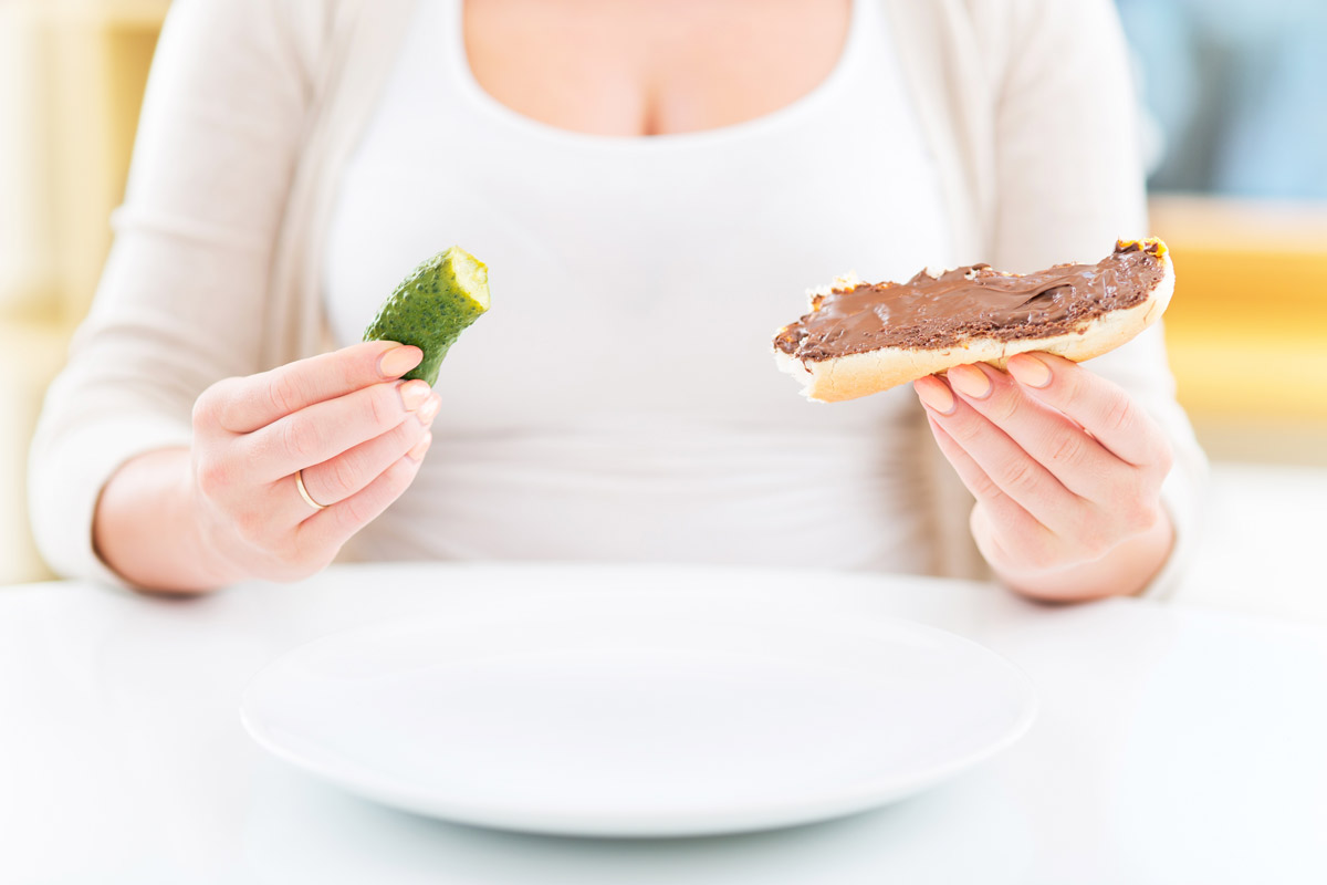 Woman holding a pickle and chocolate sandwich