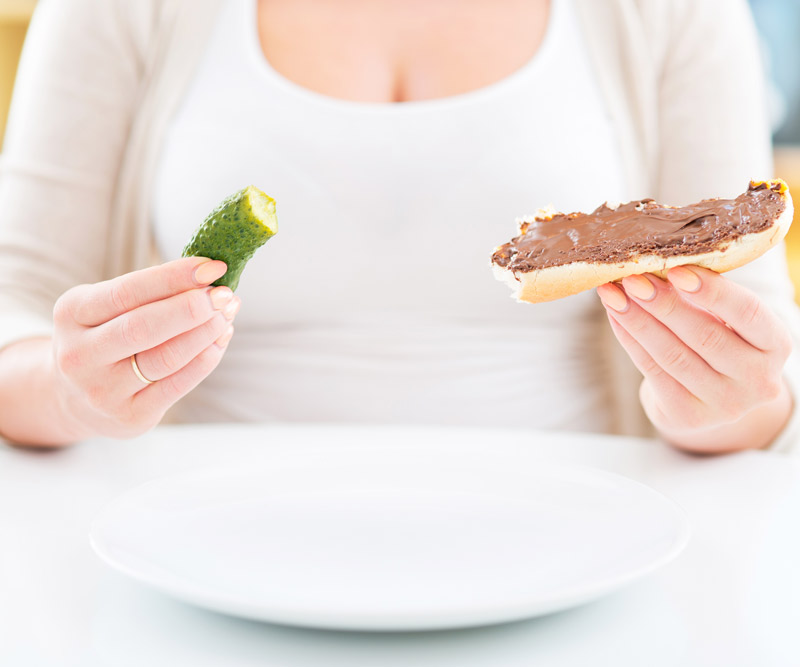 Woman holding a pickle and chocolate chocolate sandwich