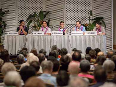 Panel of physicians sitting at table in front of audience