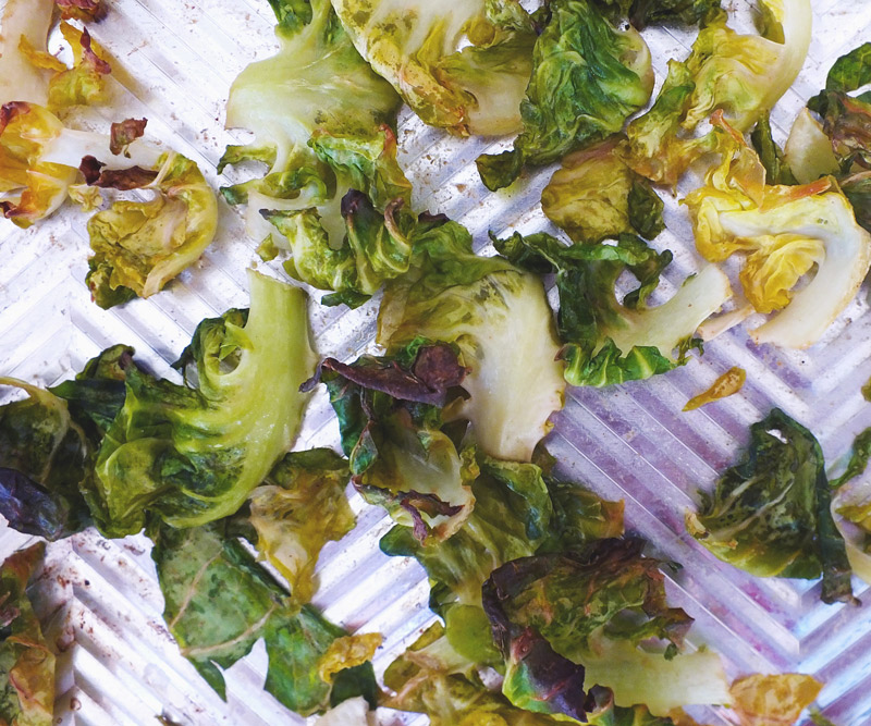 Crispy Brussels Sprout Chips on a baking sheet