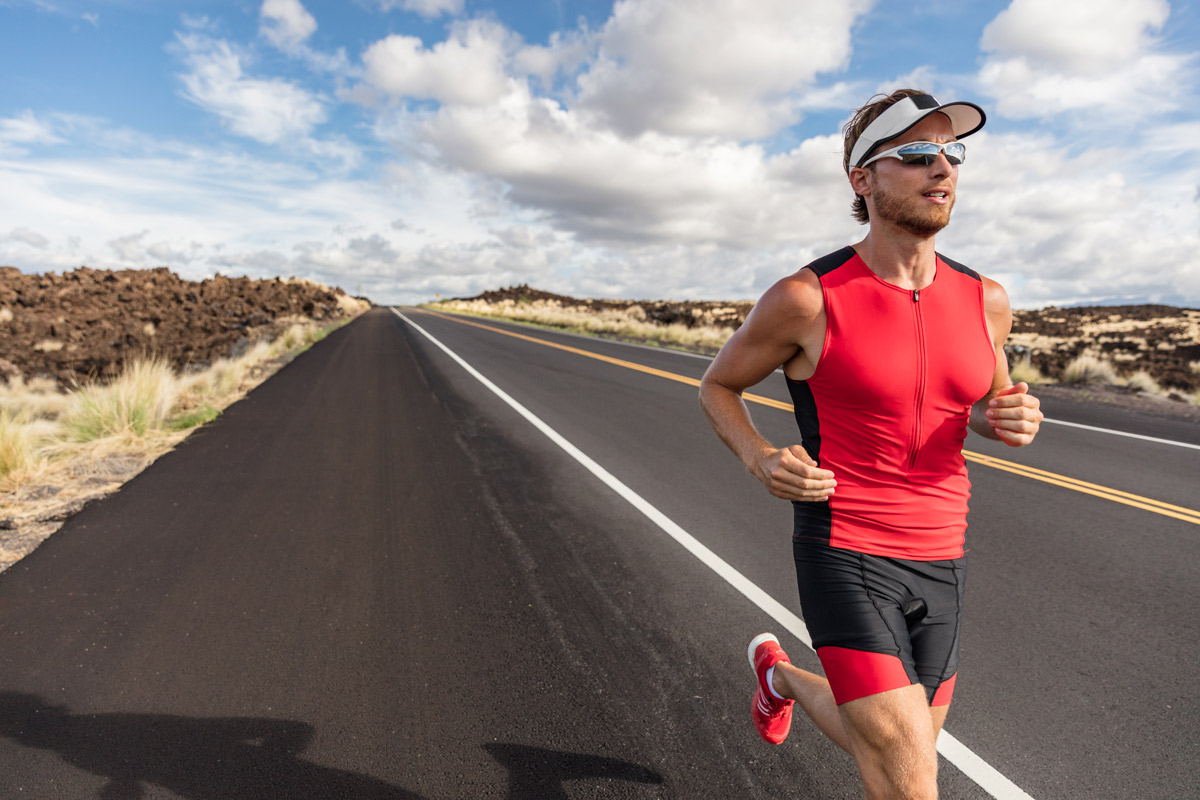 Athletic man running on a road