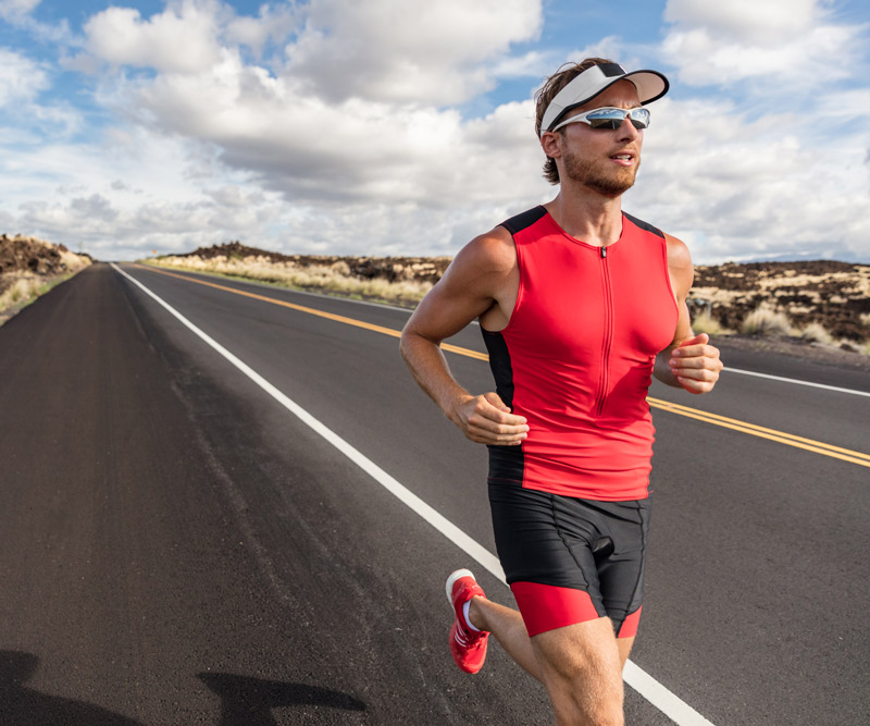 Athletic man running on a road