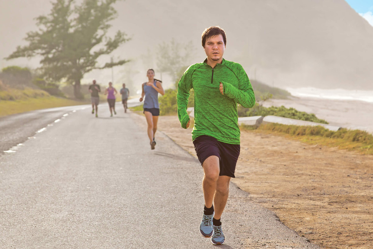 Casey Emmons running with a group of people by a beach