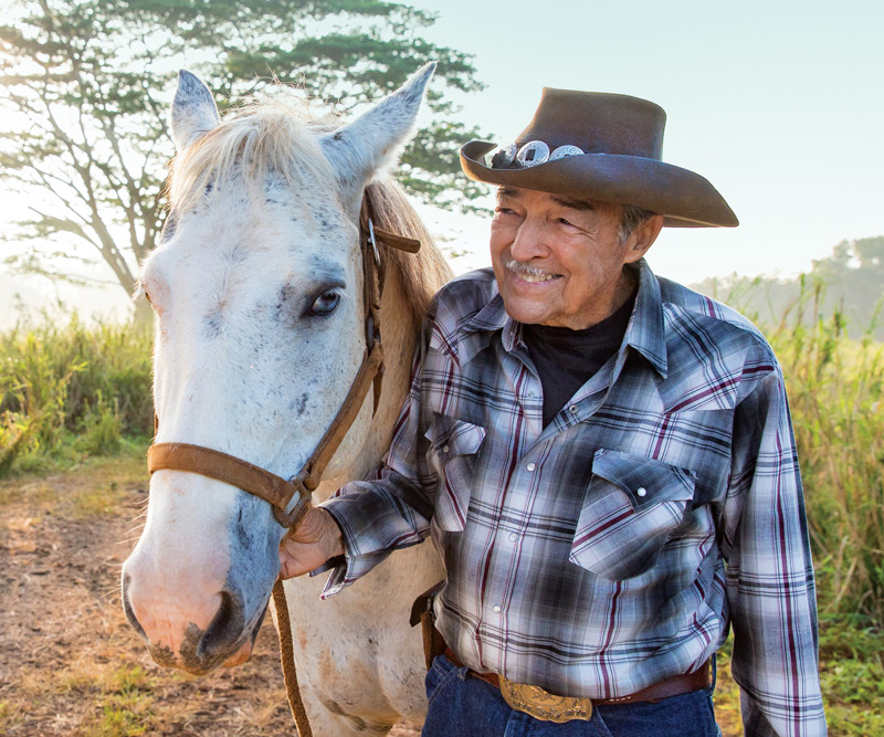 William Martin walking his horse on a trail on Kauai