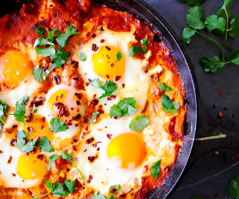 Shakshuka baked in a cast iron skillet and topped with cilantro