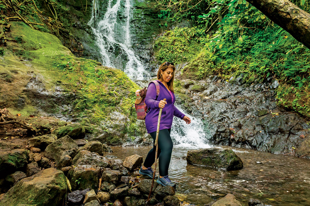 Shelly Kahalelehua-Kahapea hiking in front of a waterfall