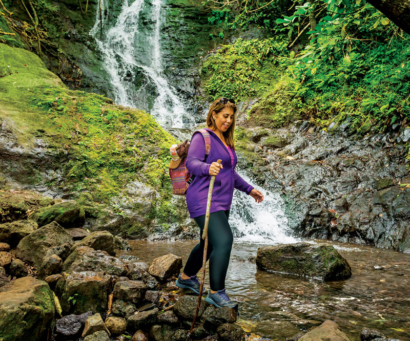 Shelly Kahalelehua-Kahapea hiking in front of a waterfall