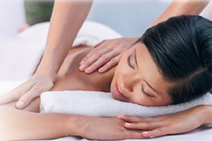 Woman laying down with her eyes closed getting a massage