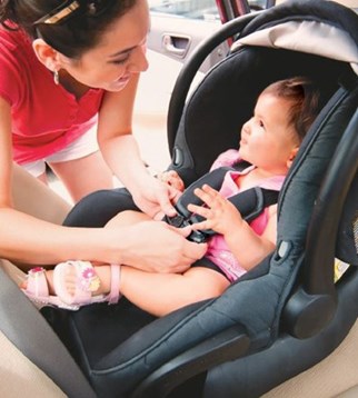 Mother buckling in her daughter in the car seat