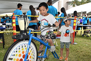 Boy riding the blender bike at kids fest