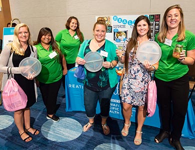 Women at the women's wellness event holding up their giveaways