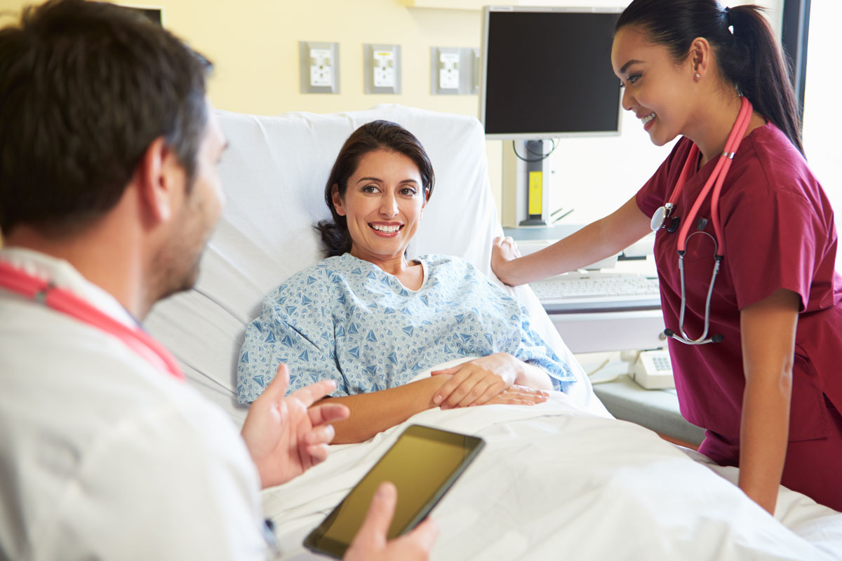doctor and nurse discussing treatment options with patient in hospital room