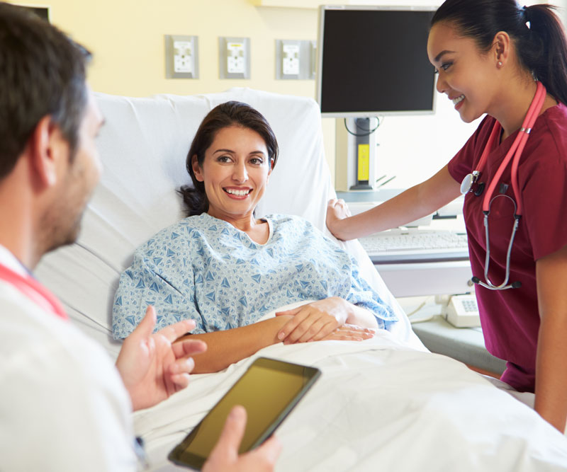 doctor and nurse discussing treatment options with patient in hospital room