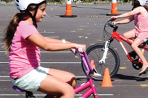 two girls riding their bikes on a training course
