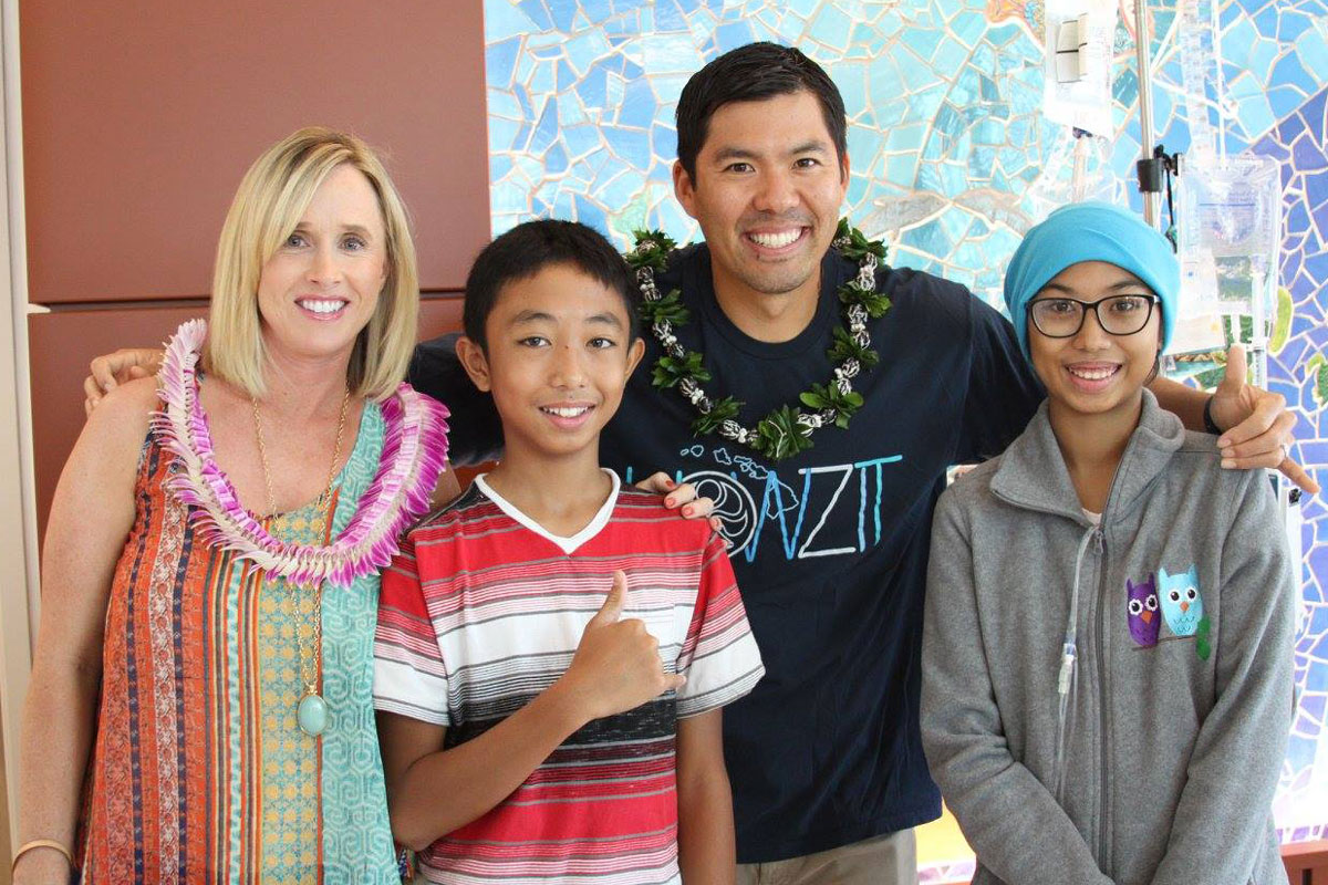 Kurt and Renee Suzuki flash a smile with two young patients at Kapiolani Medical Center.