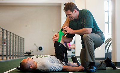 Doctor helping patient to do a physical exercise