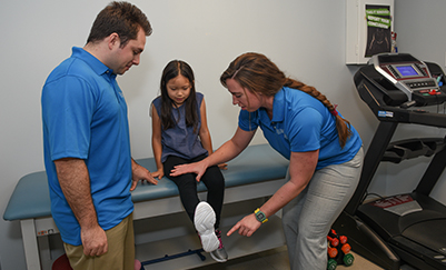 Doctors examining young patient's leg