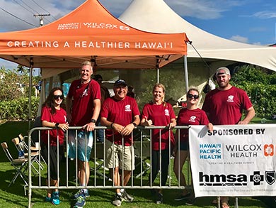 Wilcox volunteers of the 10th annual Kauai Marathon & Half Marathon standing in front of Wilcox Medical Center tent