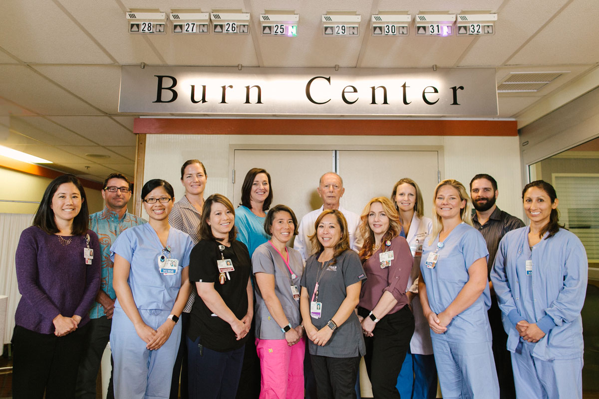 physicians and staff of the Straub Burn Center stand in front of the office doors and sign