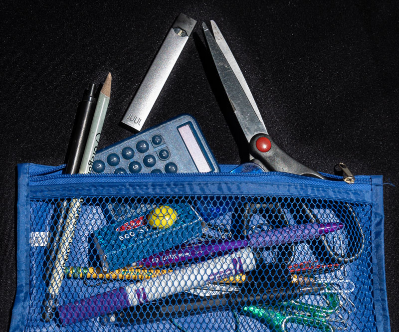 school items and a JUUL e-cigarette spilling out of a mesh bag