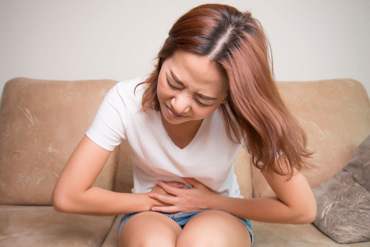 A woman clutching her sore stomach.