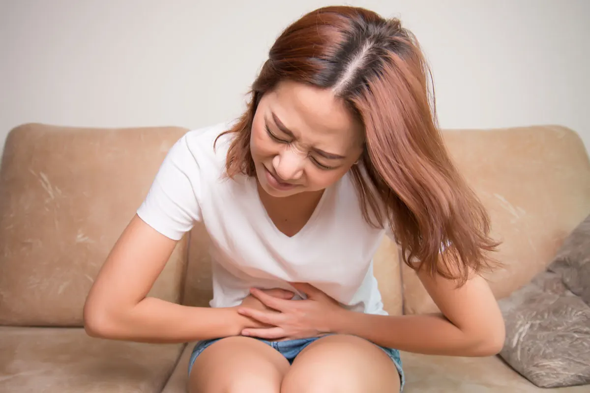A woman clutching her sore stomach.