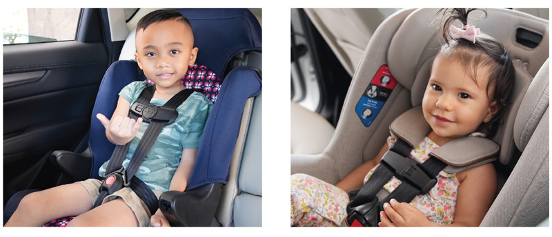 2 children safely sitting in their car seat and smiling.