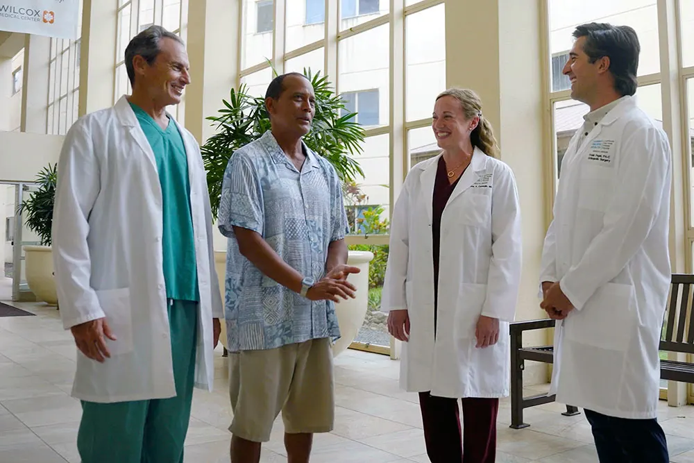 Providers and patient walking inside Wilcox Medical Center.