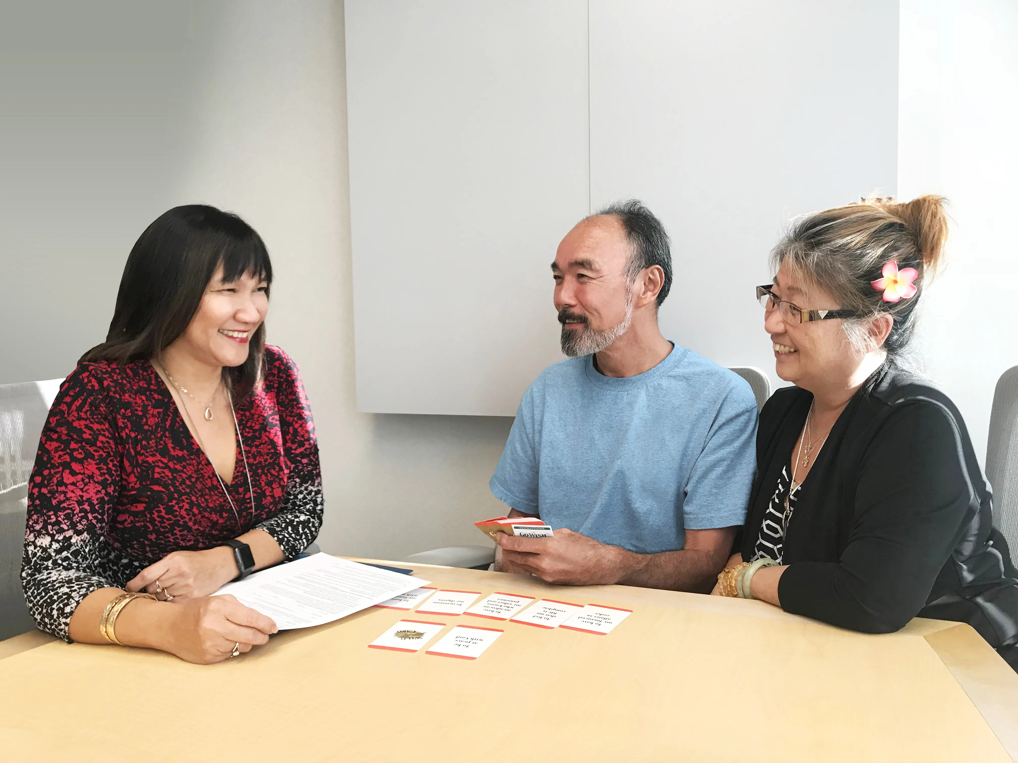 Smiling older couple meeting with an advance care planning facilitator at a table.