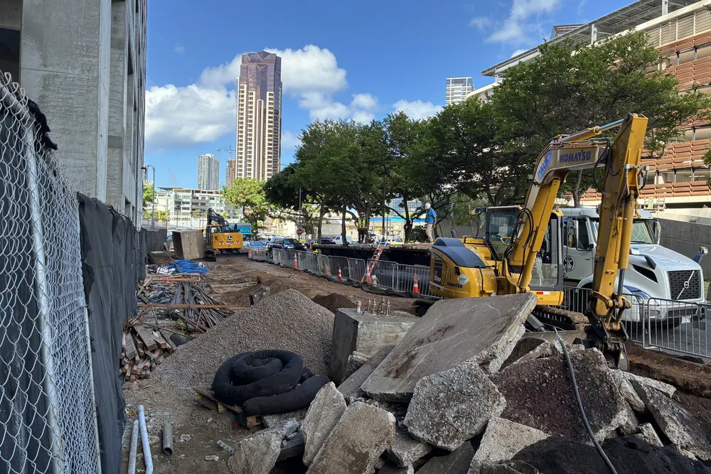 Excavators and an open utility trench along Kealamakai Street.