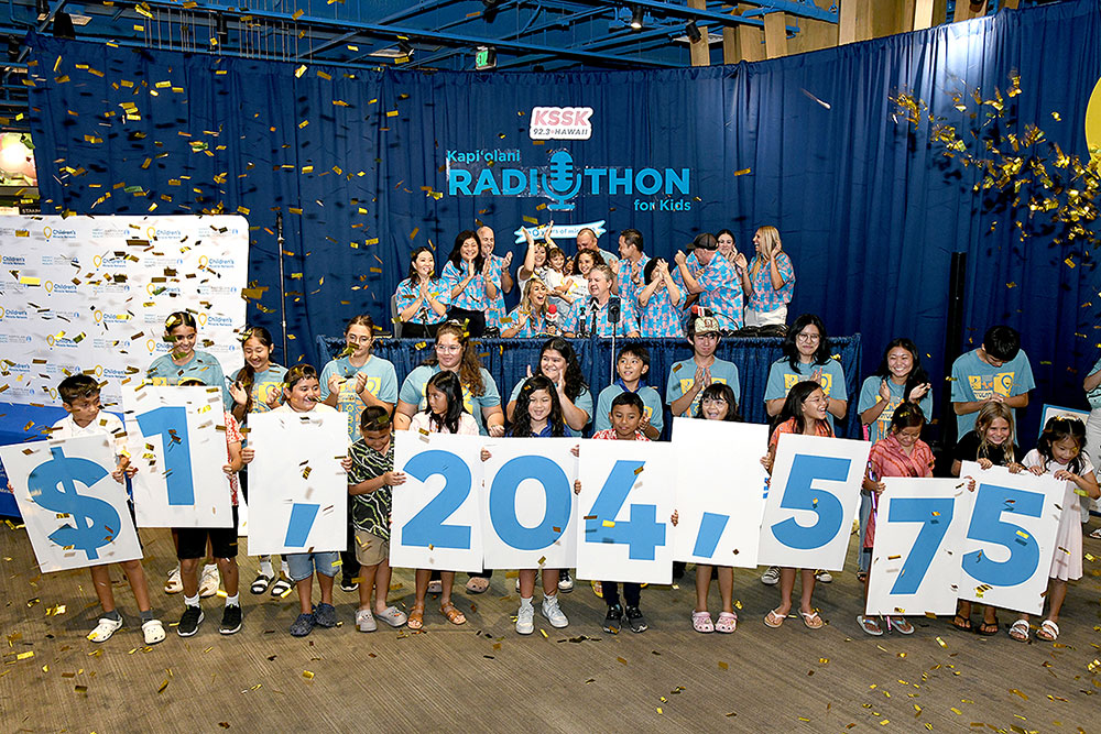 Volunteers cheering, gold confetti falling and a line of young kids holding numbers that read $1,204, 575. 