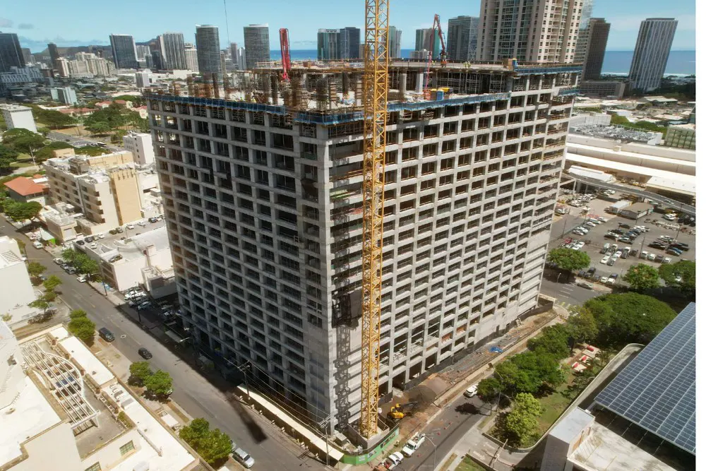 Aerial view of the parking building, tower crane, and Honolulu skyline.
